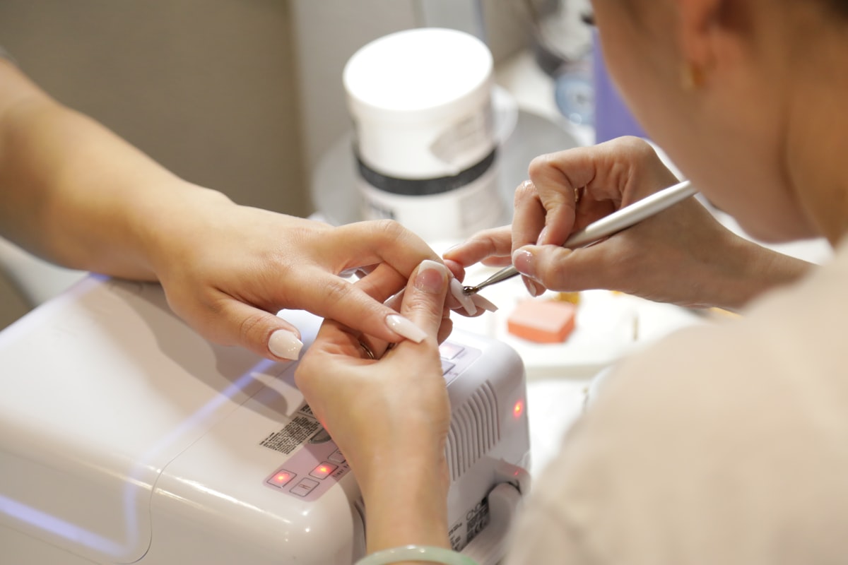 A manicurist working on a client's nails